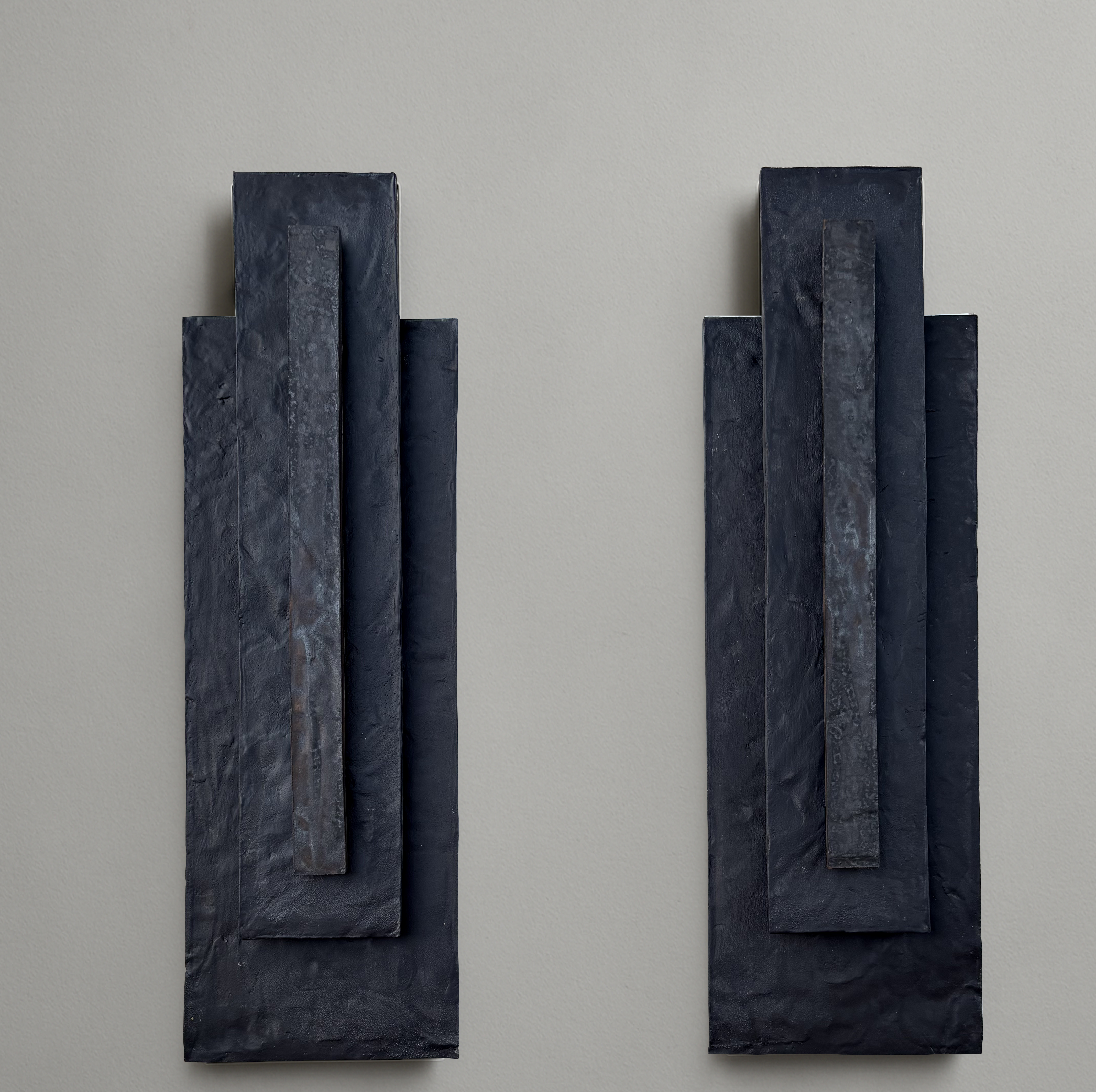 Pair of black ceramic wall sculptures, height 75 cm